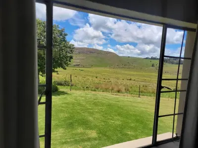 a view of a field from a window at Mountain View Farm Cottage 4X4 Vehicles ONLY in Dullstroom