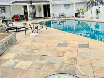 a swimming pool with a table and chairs next to it at Wölfe Krantz Accommodation in Nelspruit