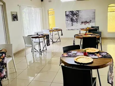 a room with tables and chairs in a restaurant at Wölfe Krantz Accommodation in Nelspruit