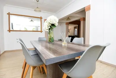 a dining room table with chairs and a vase of flowers at Spacious Menlyn Maine Villa in Pretoria