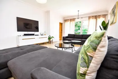 a living room with a couch and a tv at Spacious Menlyn Maine Villa in Pretoria