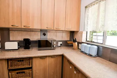a kitchen with wooden cabinets and a counter top at Spacious Menlyn Maine Villa in Pretoria