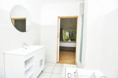 a bathroom with a sink and a mirror and a tub at Spacious Menlyn Maine Villa in Pretoria