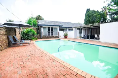 a swimming pool in a yard with a house at Spacious Menlyn Maine Villa in Pretoria