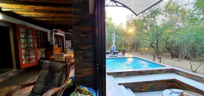 a swimming pool in a house with a window at Loerie Escape - Marloth Park in Marloth Park