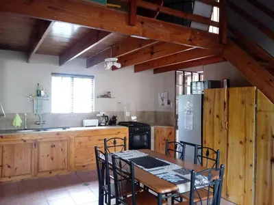 a kitchen with a table and chairs and a refrigerator at Marloth Wild Fig in Marloth Park