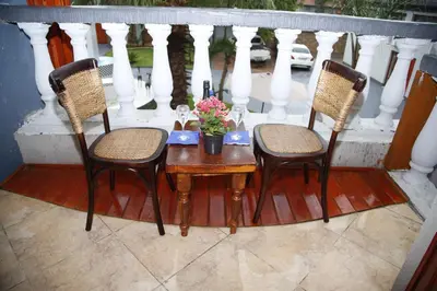 a table with two chairs and a table with flowers on a porch at Travetel OR Tambo Airport in Kempton Park