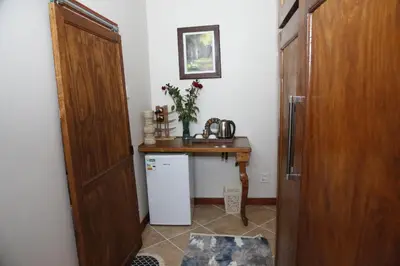 a kitchen with a table and a refrigerator in a room at Travetel OR Tambo Airport in Kempton Park