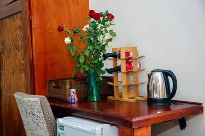 a table with a vase with flowers on it at Travetel OR Tambo Airport in Kempton Park