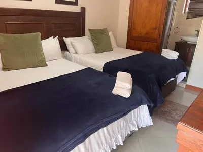 two beds sitting next to each other in a room at Travetel OR Tambo Airport in Kempton Park