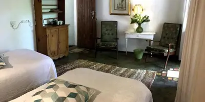 a bedroom with two beds and a desk and chairs at Old Joe's Kaia in Schoemanskloof