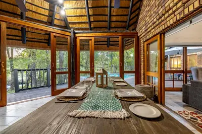 a dining room with a long table in a house at Kruger Park Lodge - IKZ2 - 3 Bedroom Chalet in Hazyview