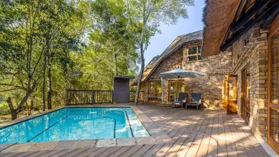 a patio with a swimming pool next to a house at Kruger Park Lodge - IKZ2 - 3 Bedroom Chalet in Hazyview