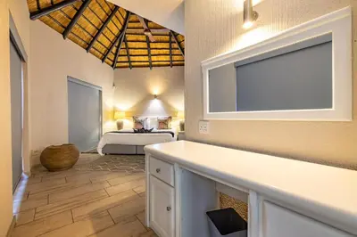 a bedroom with a bed in the background at Kruger Park Lodge - IKZ2 - 3 Bedroom Chalet in Hazyview