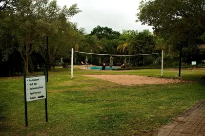 a volleyball net in a park with a sign in the grass at Kruger Park Lodge - IKZ2 - 3 Bedroom Chalet in Hazyview