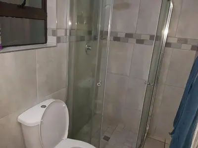 a bathroom with a toilet and a glass shower at Good 2 Go Guest House in Benoni