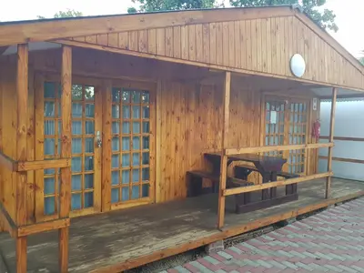 a wooden building with a porch with a desk at Good 2 Go Guest House in Benoni