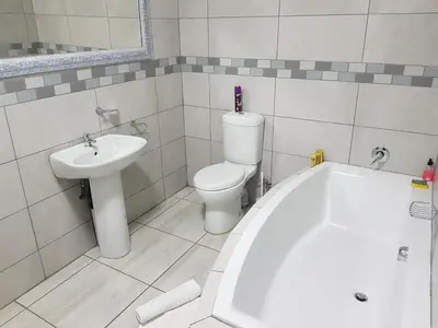 a bathroom with a sink and a toilet and a tub at Good 2 Go Guest House in Benoni