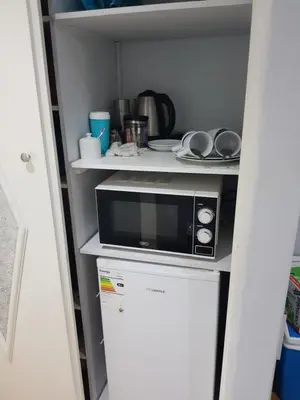 a microwave sitting on top of a refrigerator in a kitchen at Good 2 Go Guest House in Benoni