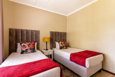 a bedroom with two beds and a lamp at 34 NOLE, 2 bed 2 bath apartment in Midrand
