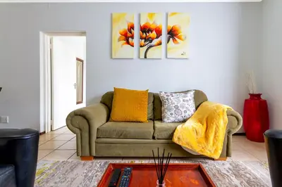 a living room with a couch and two paintings on the wall at 34 NOLE, 2 bed 2 bath apartment in Midrand