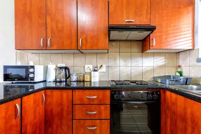 a kitchen with wooden cabinets and a stove top oven at 34 NOLE, 2 bed 2 bath apartment in Midrand