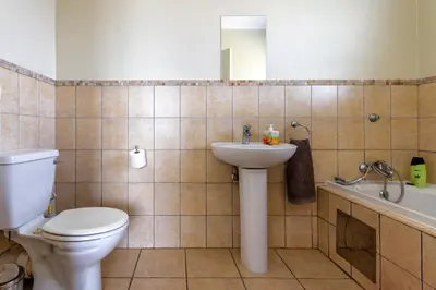 a bathroom with a toilet and a sink and a tub at 34 NOLE, 2 bed 2 bath apartment in Midrand