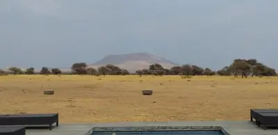 a view of a field with a mountain in the background at Kareefontein 8 Bedroom Lodge IKH1 in Mabula