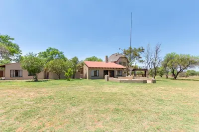 a house with a large yard in front of it at Kareefontein 8 Bedroom Lodge IKH1 in Mabula