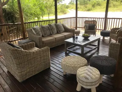 a porch with a couch and chairs and a table at Buffalo Rock Tented Camp in Hazyview