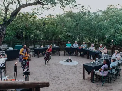 a group of people walking around in a courtyard with tables at Buffalo Rock Tented Camp in Hazyview