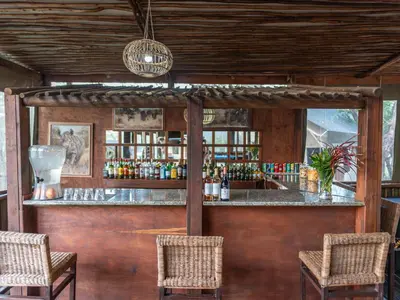 a bar in a room with two chairs at Buffalo Rock Tented Camp in Hazyview