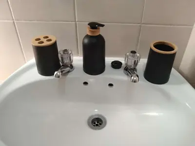 a white sink with two bottles and two rolls of toilet paper at Apartments in Menlyn Maine, at Menlyn Place in Pretoria