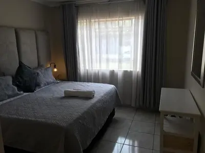 a bedroom with a large bed with a window at Apartments in Menlyn Maine, at Menlyn Place in Pretoria