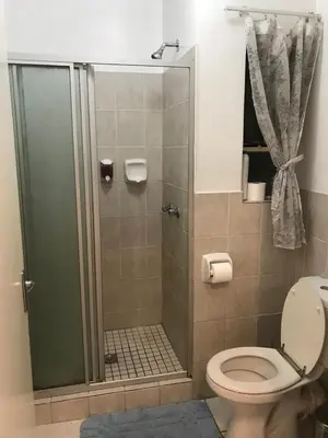a bathroom with a shower with a toilet at Apartments in Menlyn Maine, at Menlyn Place in Pretoria