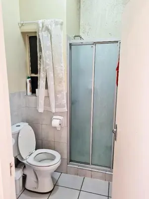 a bathroom with a toilet and a glass shower at Apartments in Menlyn Maine, at Menlyn Place in Pretoria