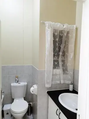 a bathroom with a white toilet and a sink at Apartments in Menlyn Maine, at Menlyn Place in Pretoria
