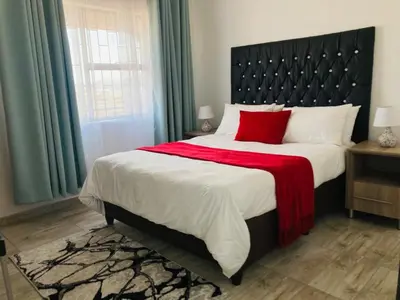 a bedroom with a large bed with a red blanket at Molas Luxury Accomodation in Ga-Mothiba