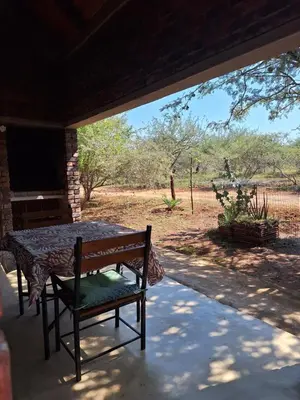 a patio with a table and a chair on a porch at Marloth Wild Fig Studio in Marloth Park