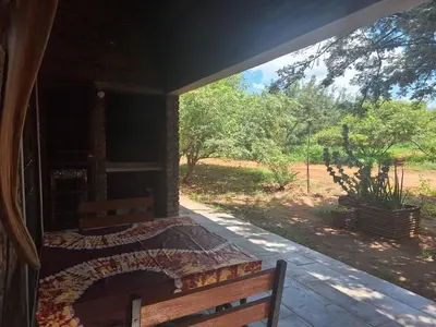 a porch of a house with a bed and a bench at Marloth Wild Fig Studio in Marloth Park