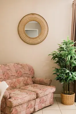 a living room with a couch and a mirror at St George's Guest House in Tzaneen