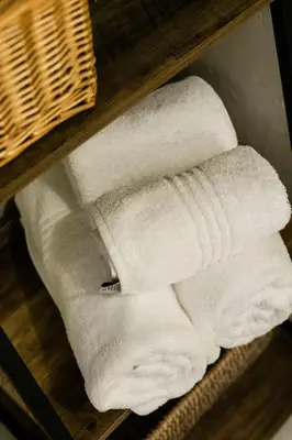 a stack of white towels on a shelf at St George's Guest House in Tzaneen