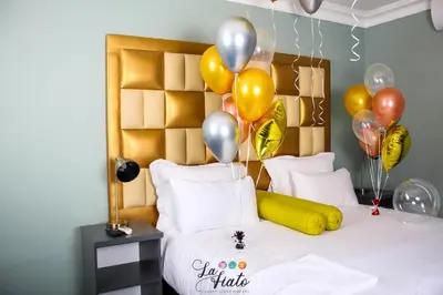 a bedroom with a bed with balloons and a bed with a bed at La Fiato Luxury Lodge in Dalmada AH