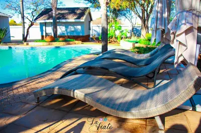 two lounge chairs next to a swimming pool at La Fiato Luxury Lodge in Dalmada AH