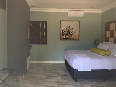 a bedroom with a bed and a painting on the wall at La Fiato Luxury Lodge in Dalmada AH