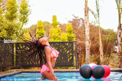a little girl standing in a swimming pool at La Fiato Luxury Lodge in Dalmada AH