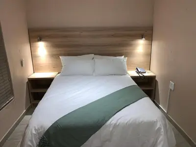 a bedroom with a large bed with two night stands at The Hill Lodge in Thohoyandou