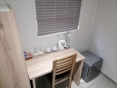 a small kitchen with a wooden desk with a microwave at The Hill Lodge in Thohoyandou