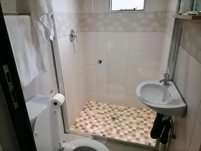 a small bathroom with a toilet and a sink at The Hill Lodge in Thohoyandou