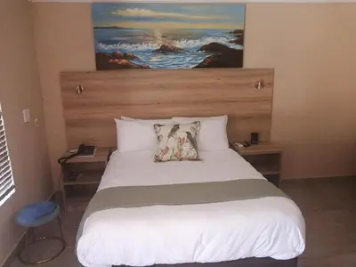 a bedroom with a large bed with two pillows on it at The Hill Lodge in Thohoyandou